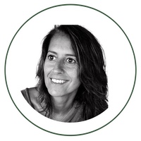 Retrato en blanco y negro de una mujer sonriente, con cabello de longitud media, mirando ligeramente hacia un lado, dentro de un marco circular.